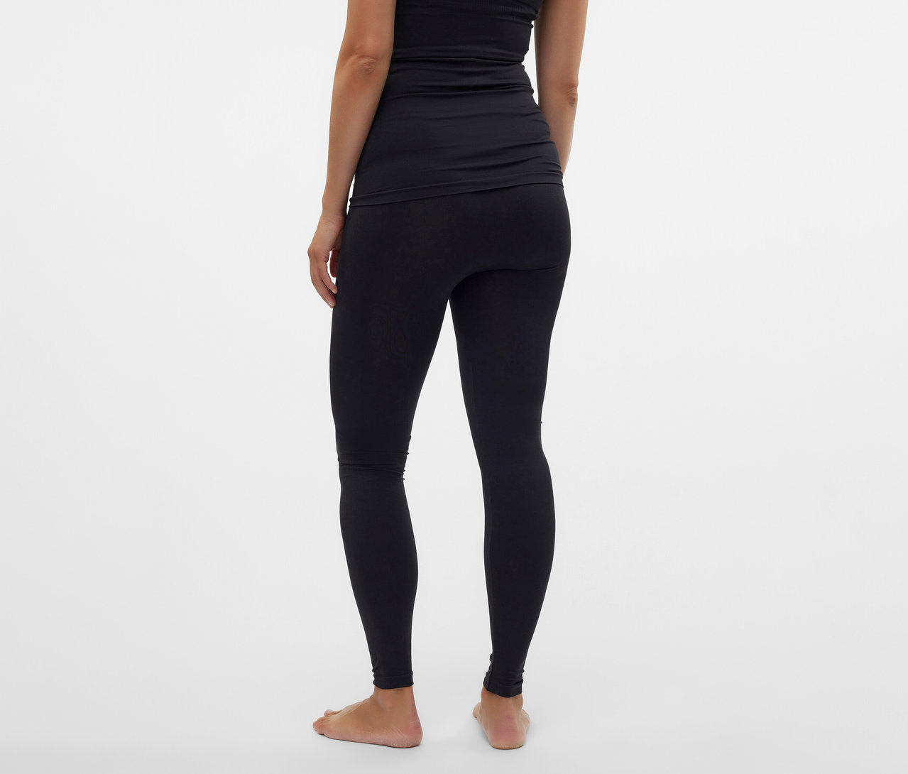 Hátulnézet egy fekete MAMALICIOUS kismama leggingset és fekete felsőt viselő nőről, fehér háttér előtt.