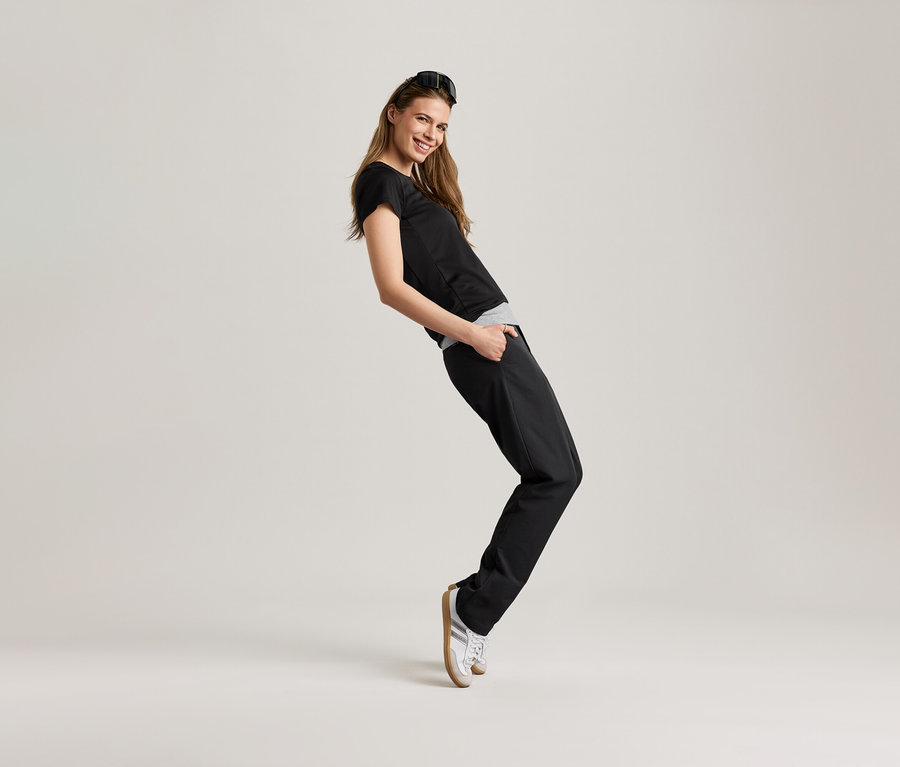 Nő pózol fekete sportfelsőben.