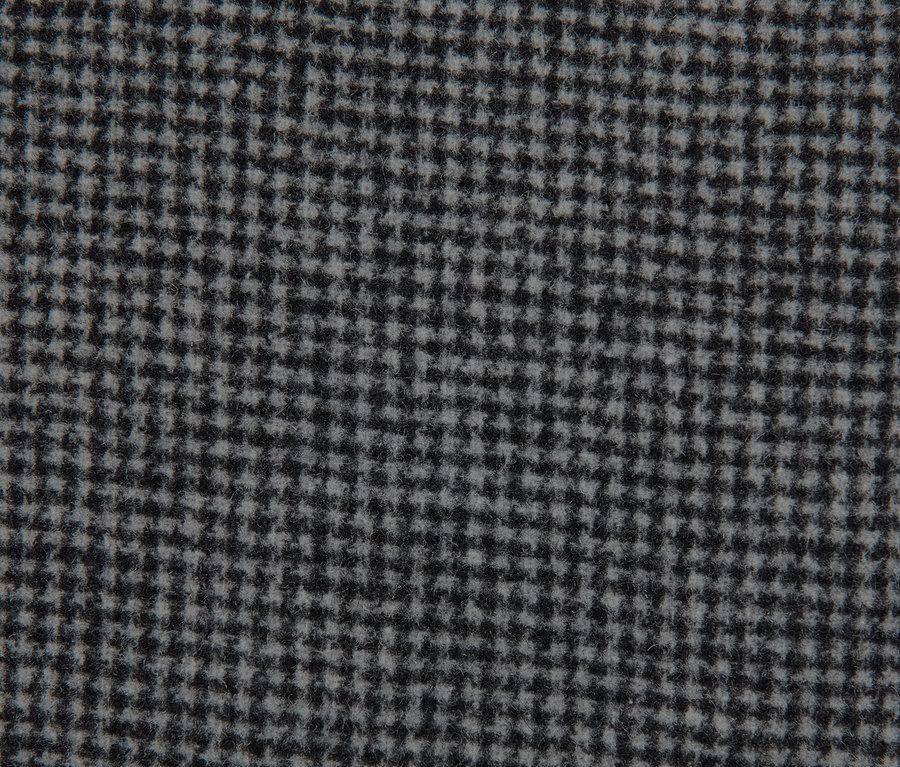A szürke, gyapjú férfi szövetkabát kockás anyagának közeli képe.