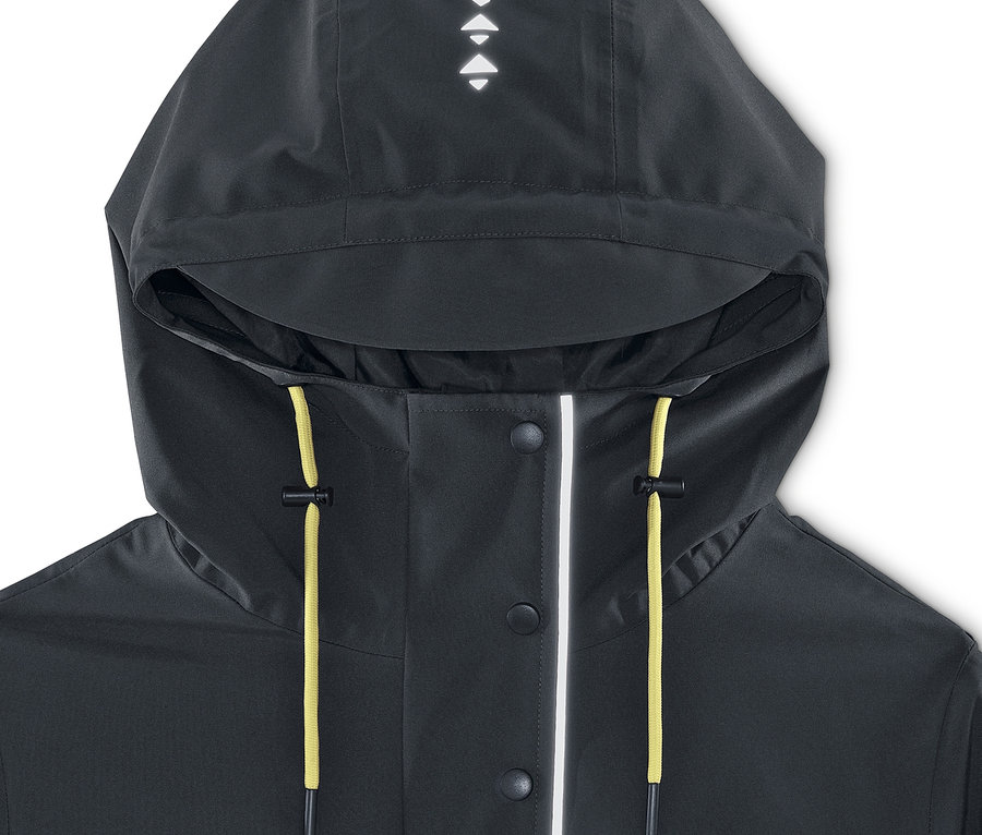 Egy sötétszürke női funkcionális parka esőkabát részlete, kapucnival és sárga zsinórokkal.