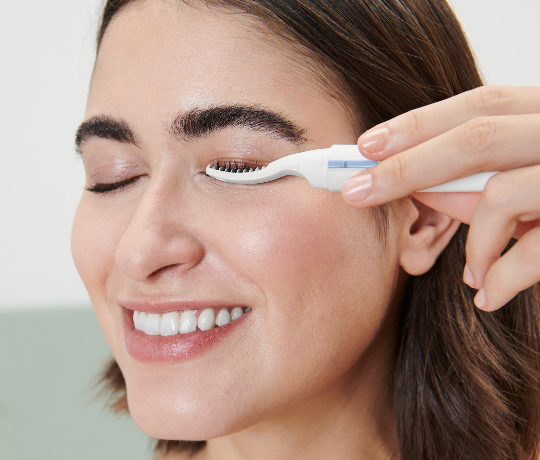 Nő elektromos szempilla-göndörítőt használ.