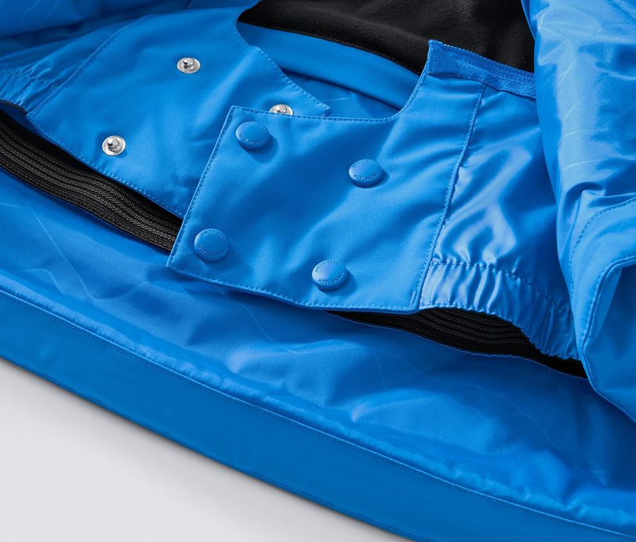 Kék high-tech síkabát részlete gombokkal és fekete szegéllyel.