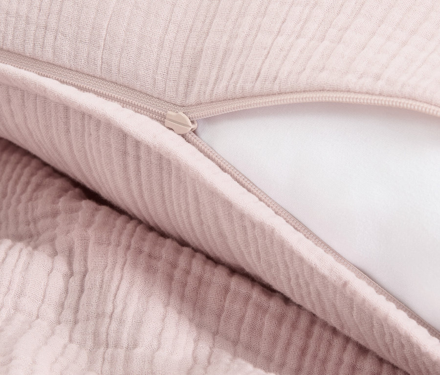 Egy rózsaszín muszlin ágynemű részlete cipzárral.