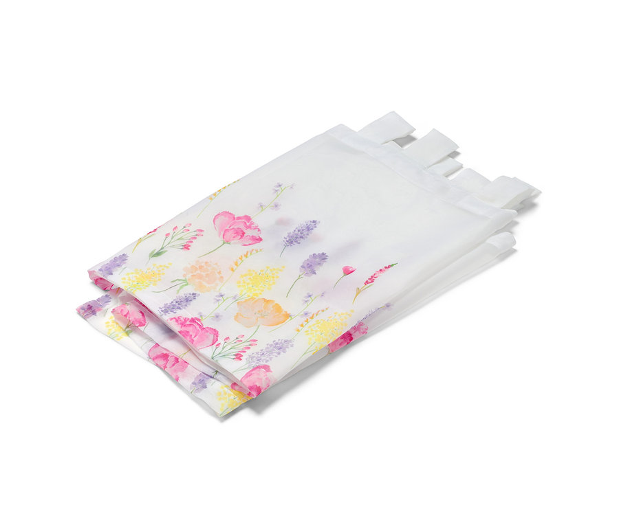 Összehajtott, virágmintás vitrázsfüggöny.