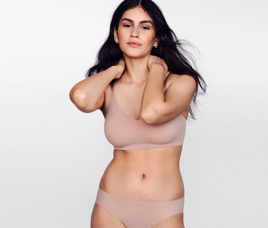 Nő pózol SCHIESSER láthatatlan, juharszínű betétes melltartóban.