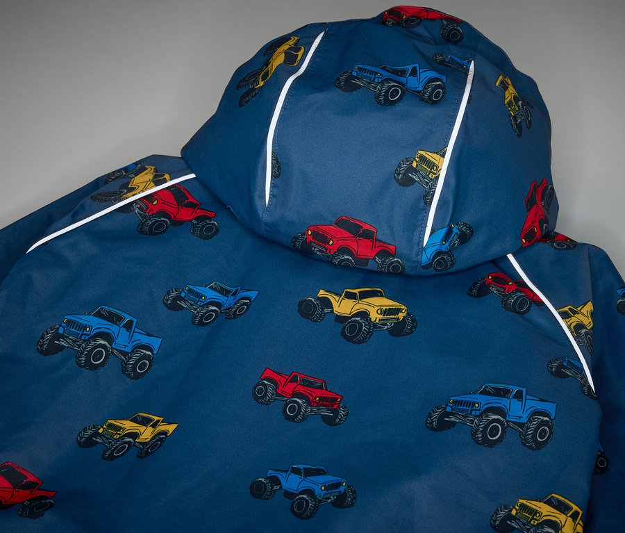 Egy gyermek termo esőkabát részlete, Monster Truck terepjáró-mintával.