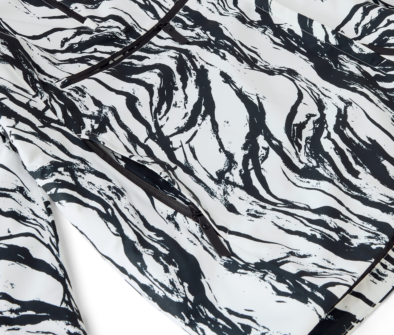 Egy fehér pizsama részlete fekete absztrakt mintával és szegéllyel.