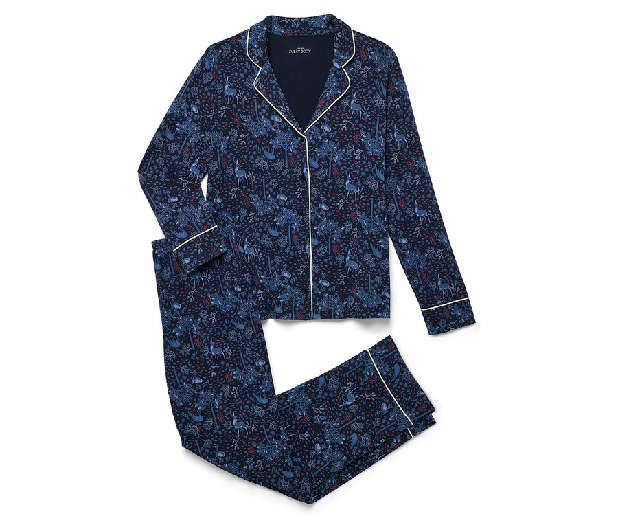 Egy sötétkék, mintás pizsama szett fekszik összehajtva egy fehér háttéren.