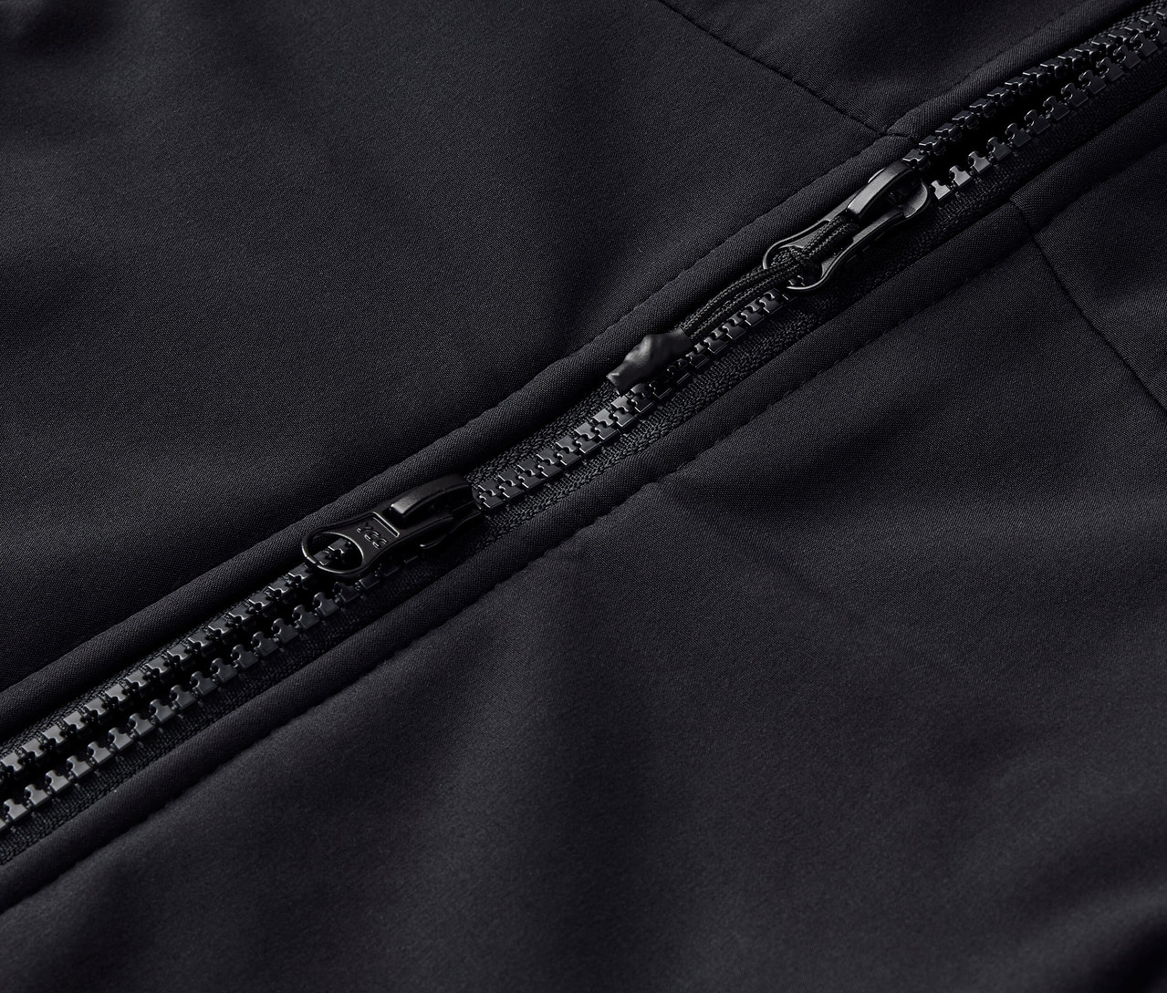 Egy fekete cipzár részlete egy ruhadarabon.