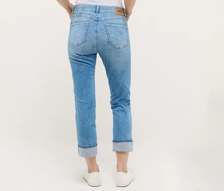 Egy személy Angels denim »Cira Boho« farmert és fehér cipőt visel.