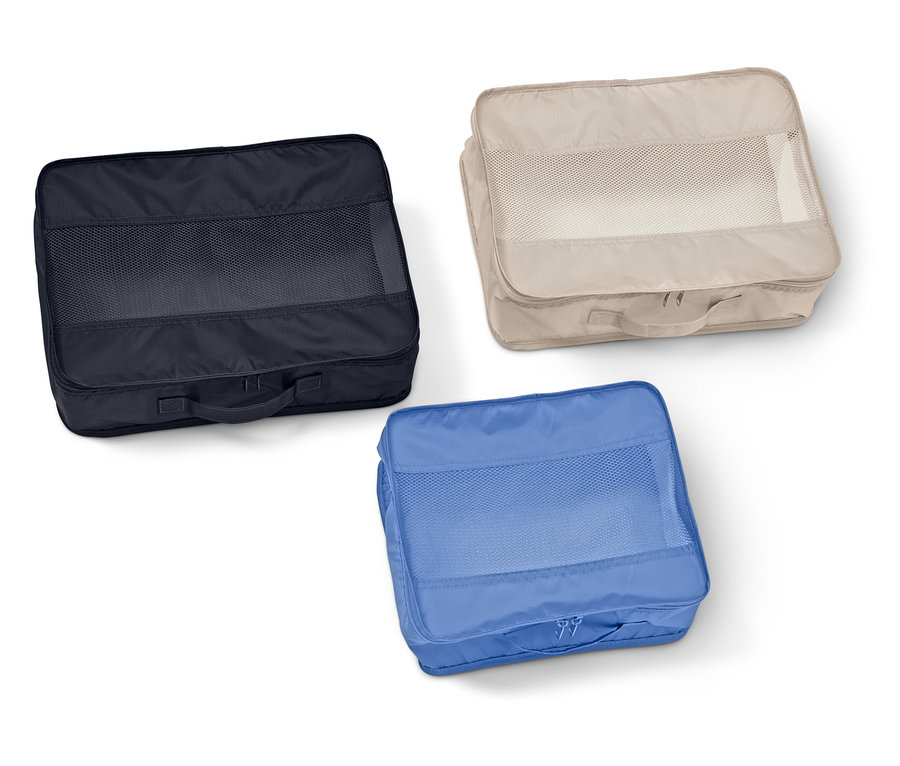 Három téglalap alakú bőröndszervező hálós ablakkal sötétkék, bézs és kék színben fekszik fehér háttéren.