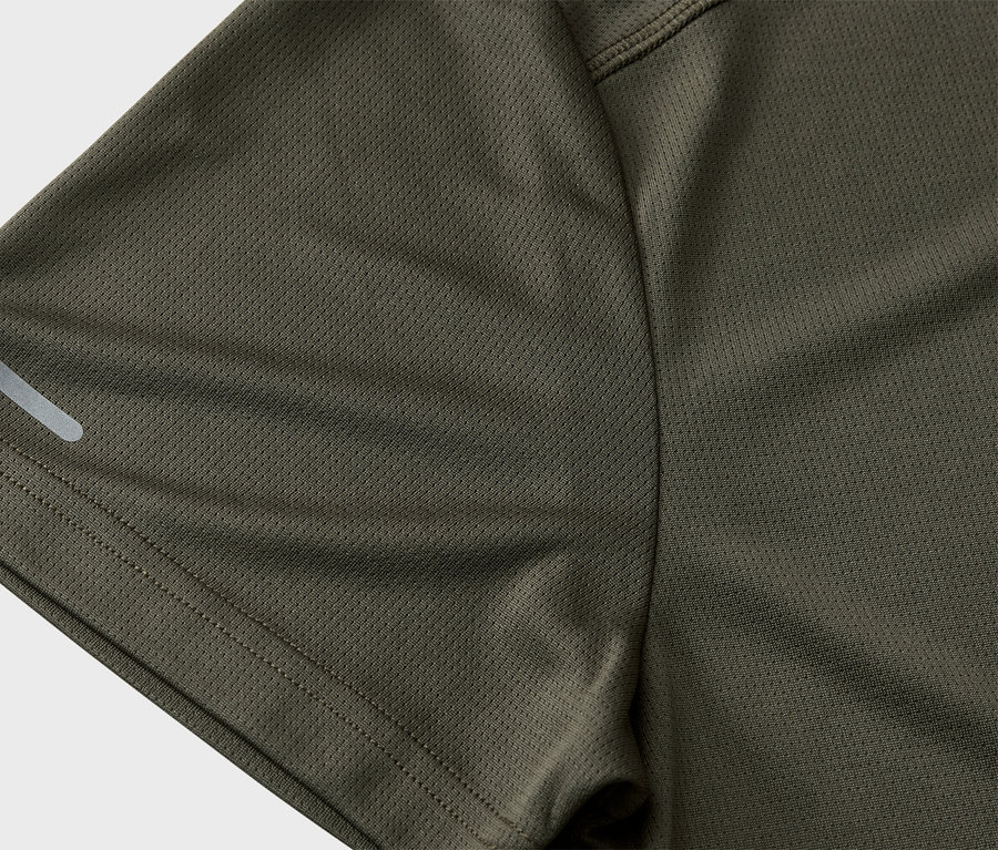 Közeli kép egy olívazöld sportmez ujjáról, fényvisszaverő csíkkal.