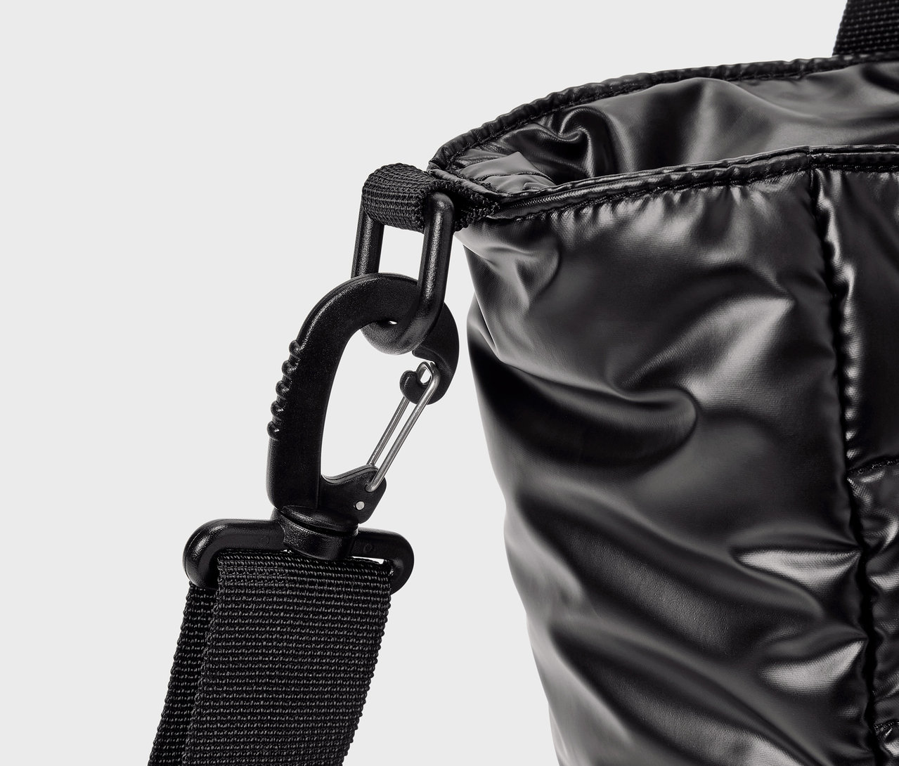 Egy fényes fekete táska részlete egy karabinerrel.