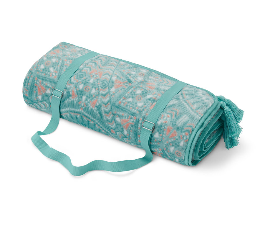 Egy feltekert XL-es pikniktakaró kék-zöld és narancssárga geometriai mintával és pántokkal.