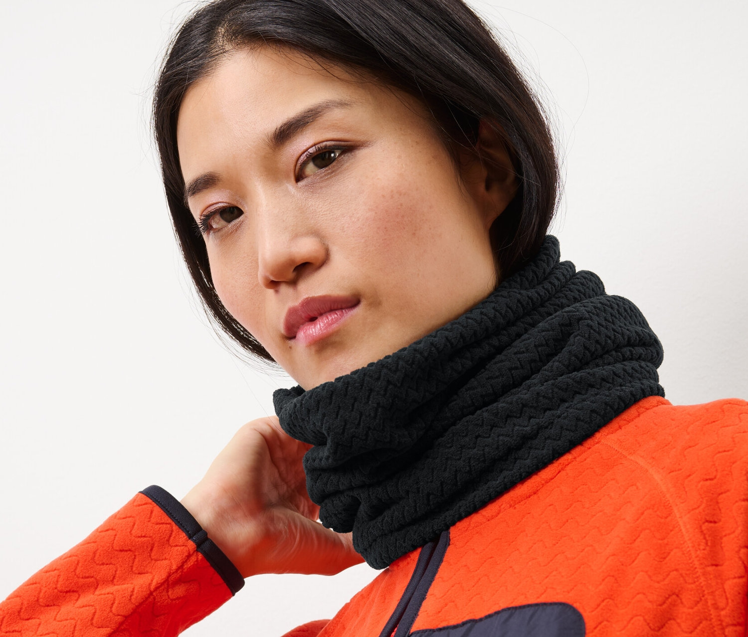 Nő visel egy fekete, strukturált polár csősált.