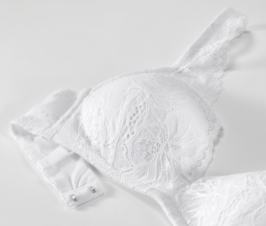 Egy fehér, csipkés, puha kosaras melltartó részlete.