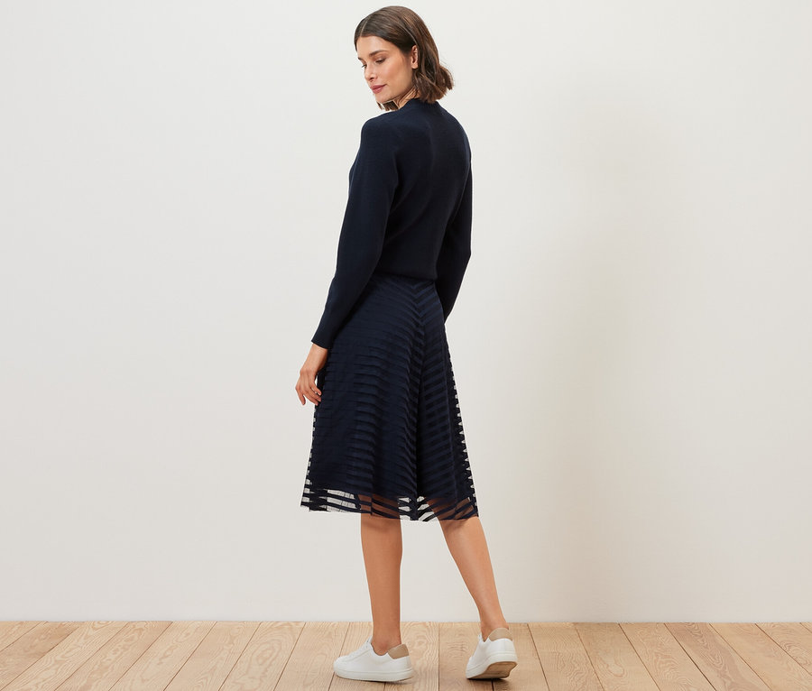 Nő pózol a sötétkék női mesh szoknyában.