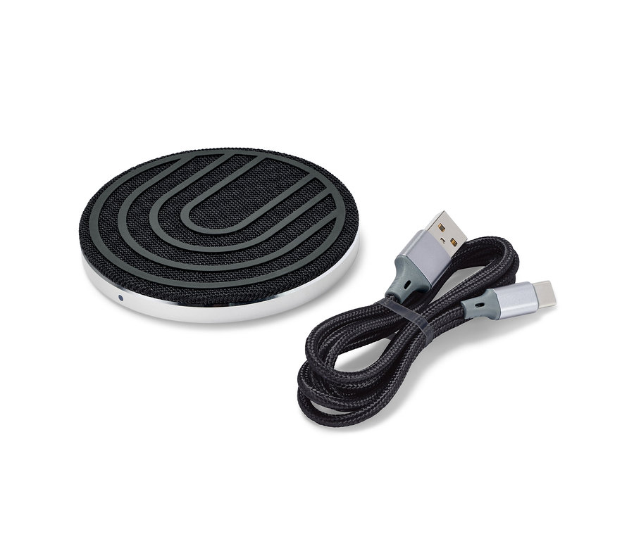 Egy fekete vezeték nélküli töltőállomás egy fekete kábel mellett.