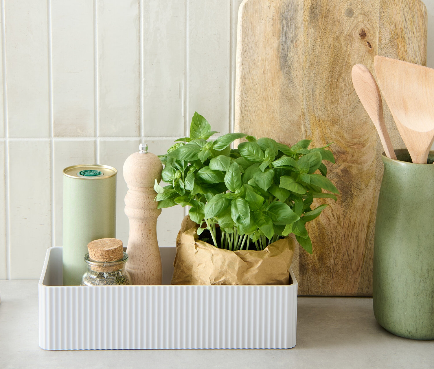 Fűszernövények, daráló és doboz egy fehér fűszertartó dobozban.