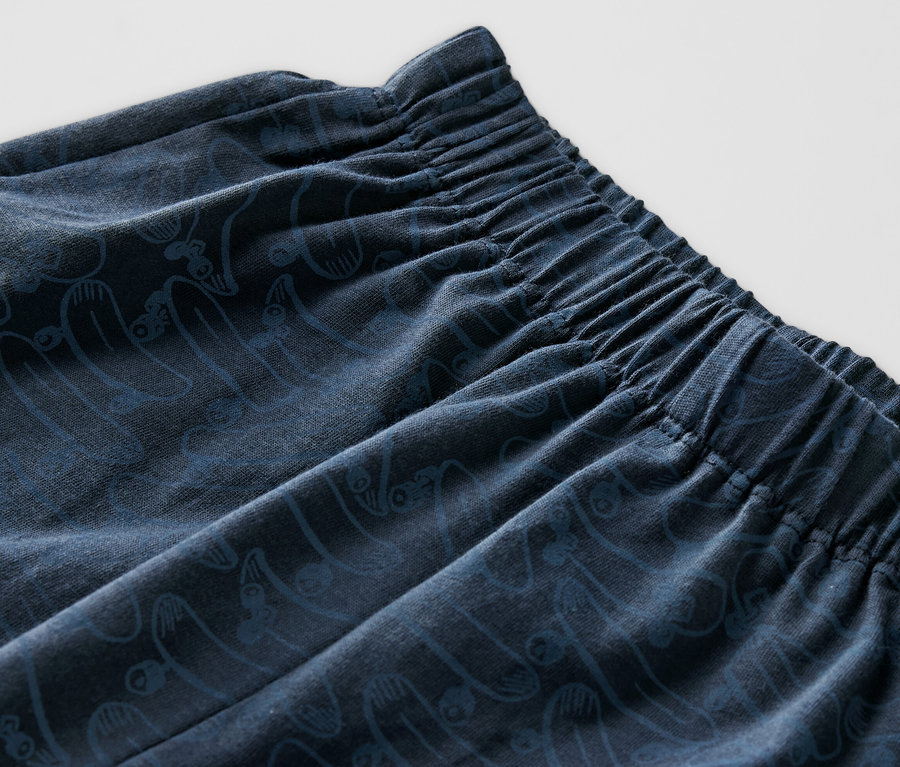 Egy rövidnadrágos gyerekpizsama részlete, gumis derékpánttal és mintával.