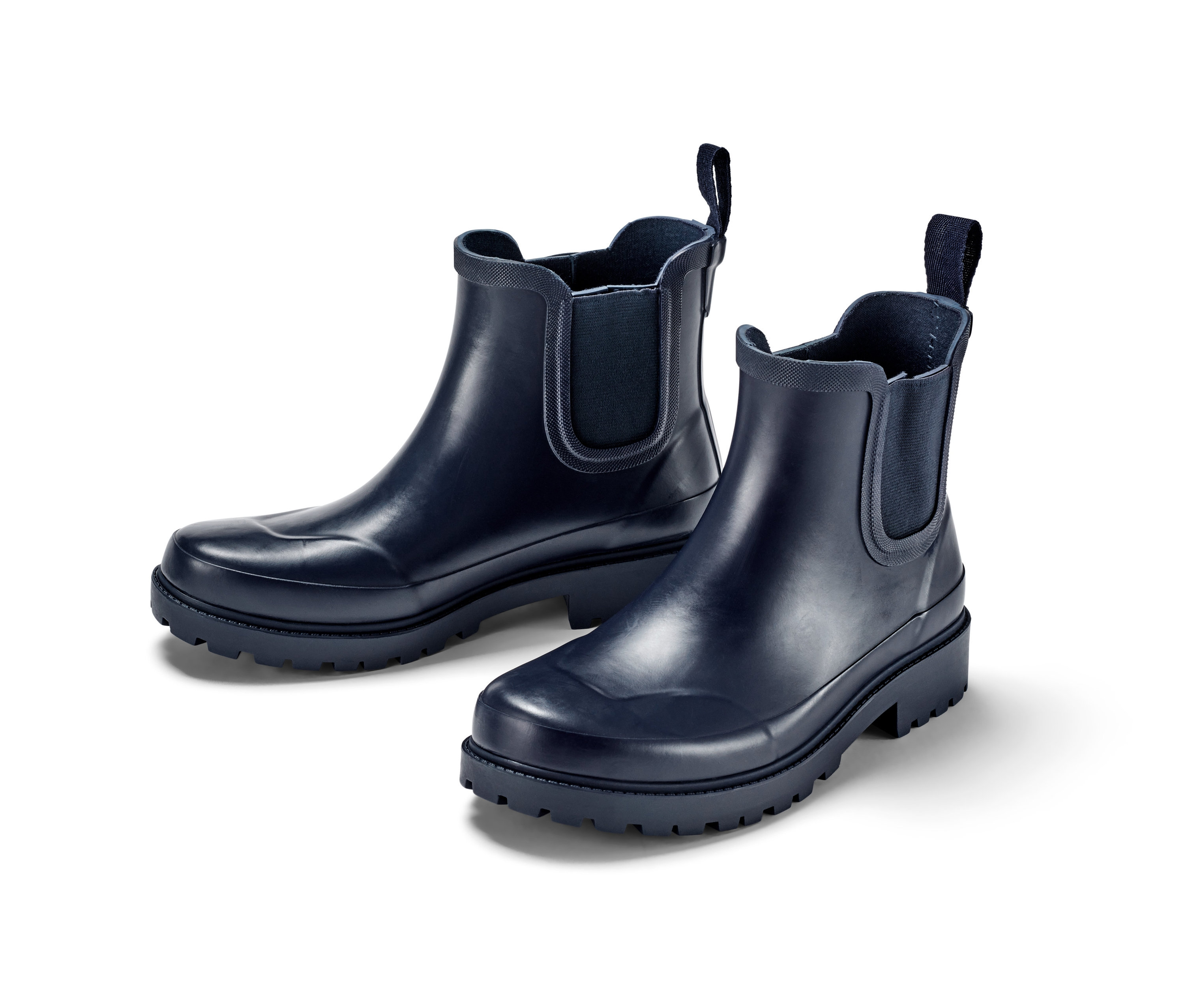 Két sötétkék női gumi bokacsizma fehér háttérrel.