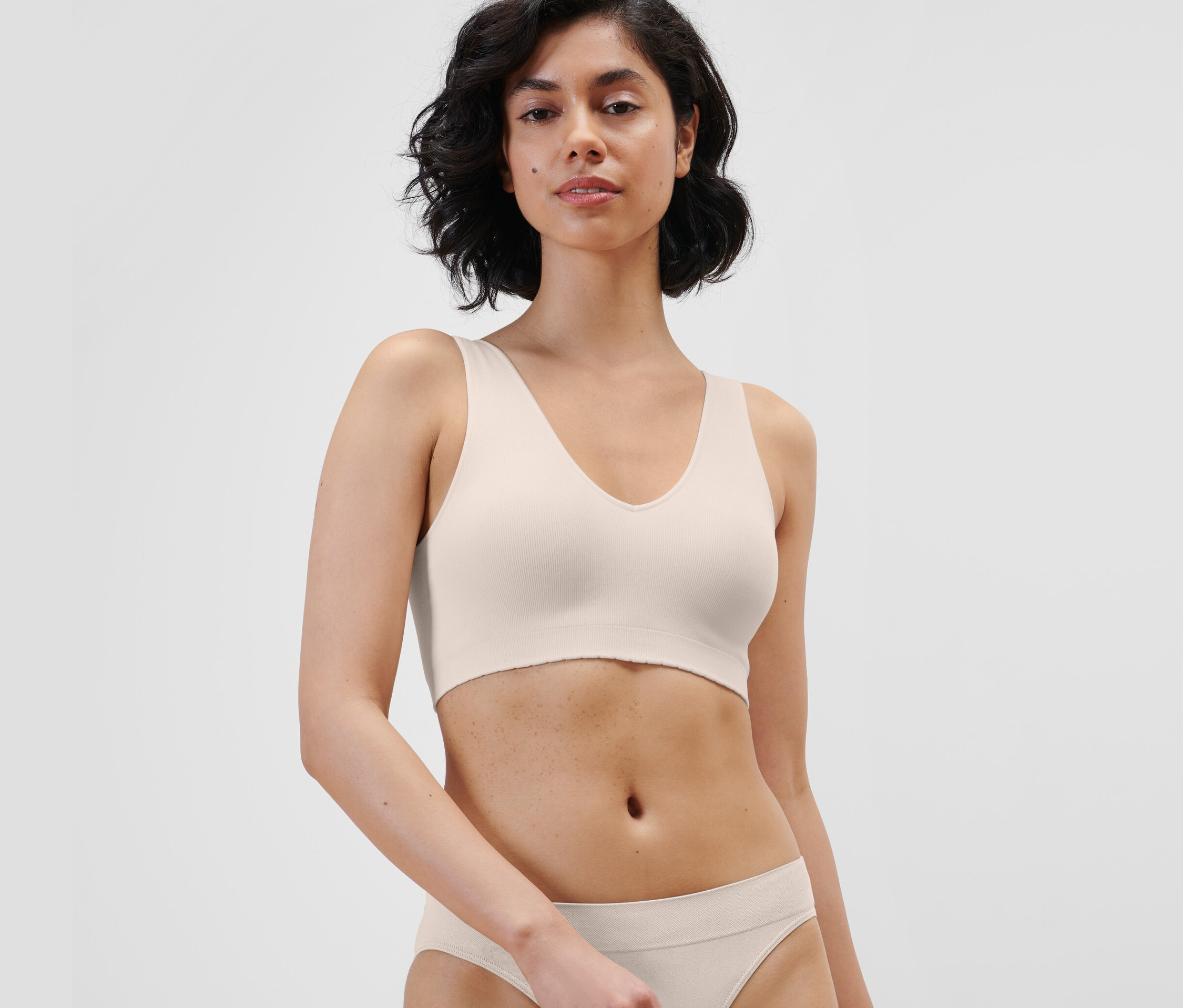 Nő krém színű, seamless bustier melltartót és alsót visel.