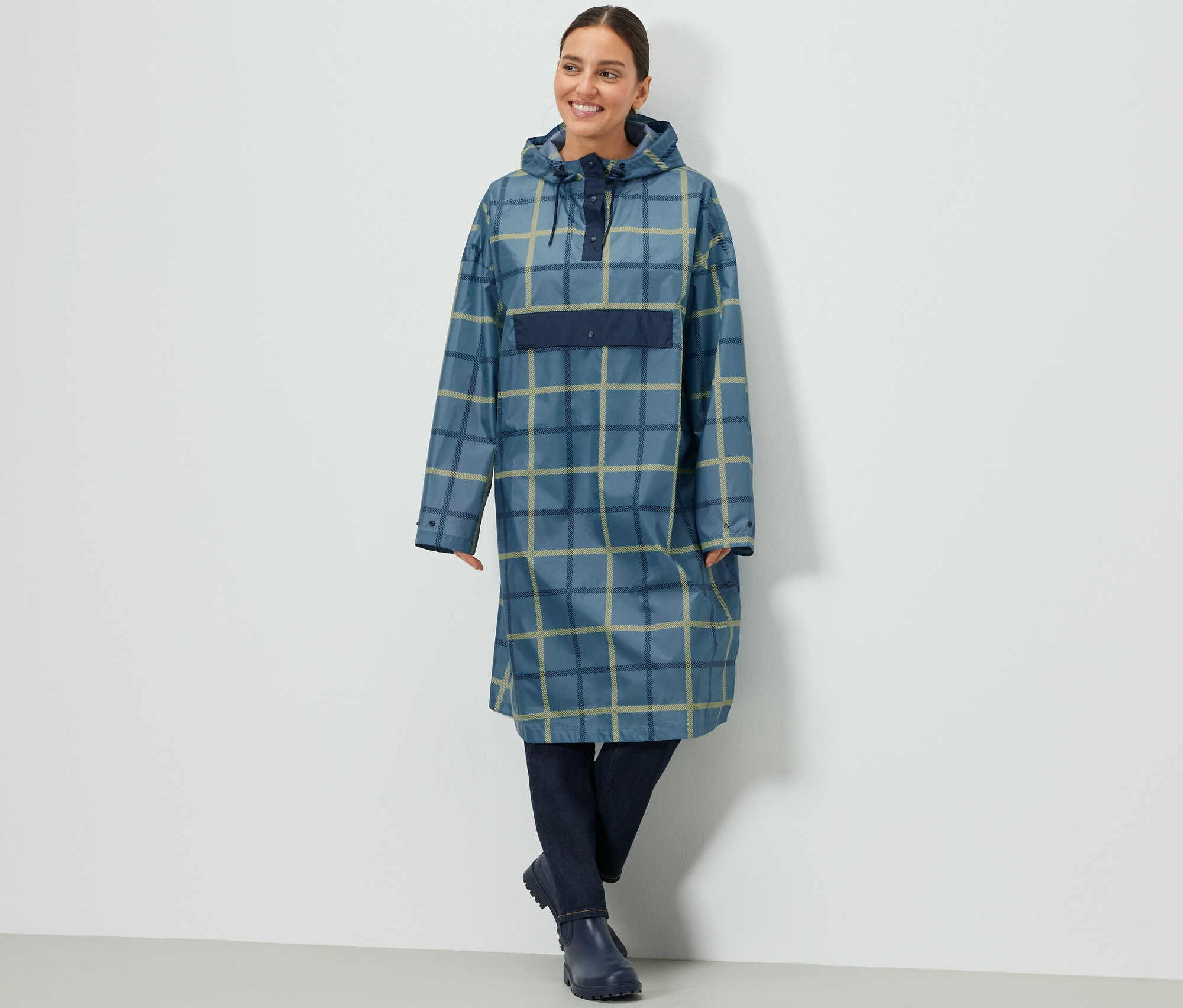 Nő kockás, uniszex poncsó esőkabátot visel.
