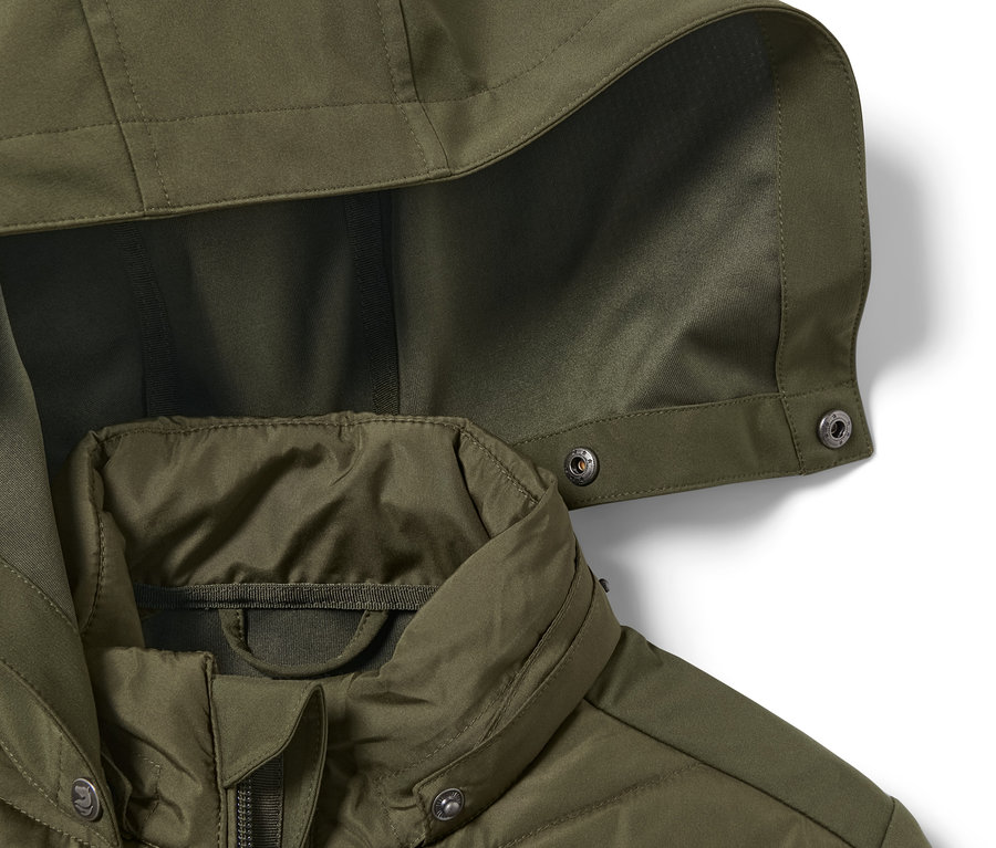 Egy olíva színű lány hibrid lovaglókabát részlete.