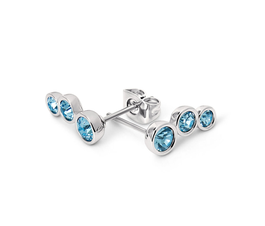 Közelkép egy pár ezüst, akvamarin színű fülbevalóról.