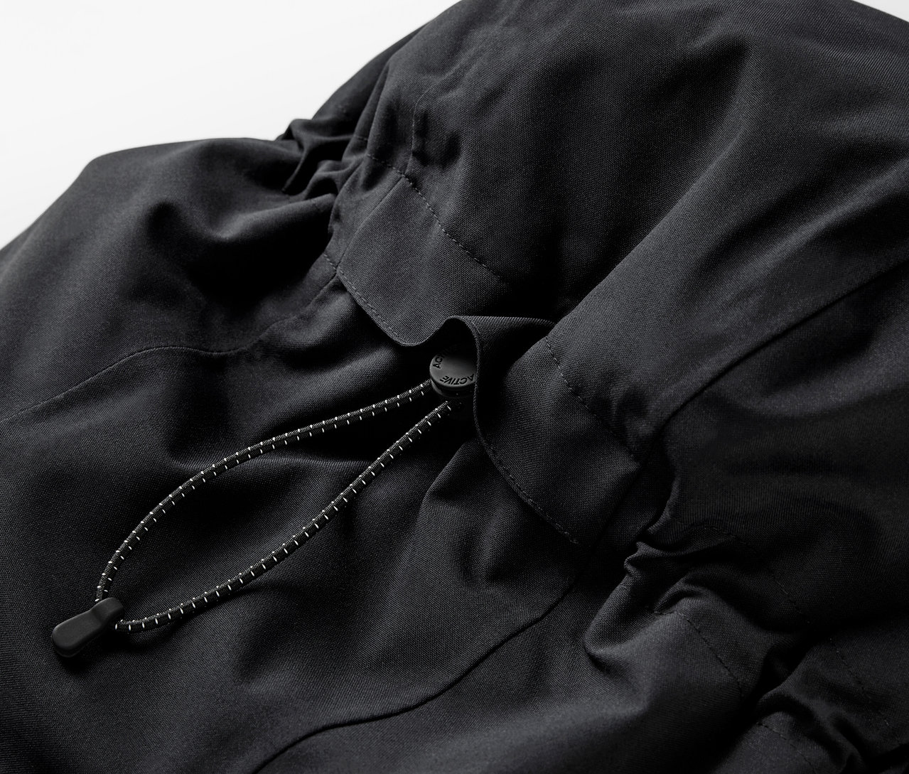 Egy fekete hátizsák részlete, húzózsinórral.