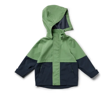 Egy zöld és sötétkék, kapucnis kisgyerek softshell dzseki fekszik.