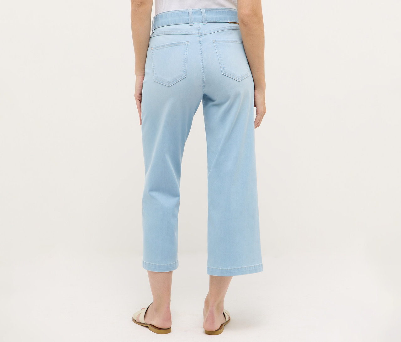 Hátulnézet egy nőről, aki Angels denim »Linn City« bokát szabadon hagyó farmernadrágot, fehérített kék színben és szandált visel.