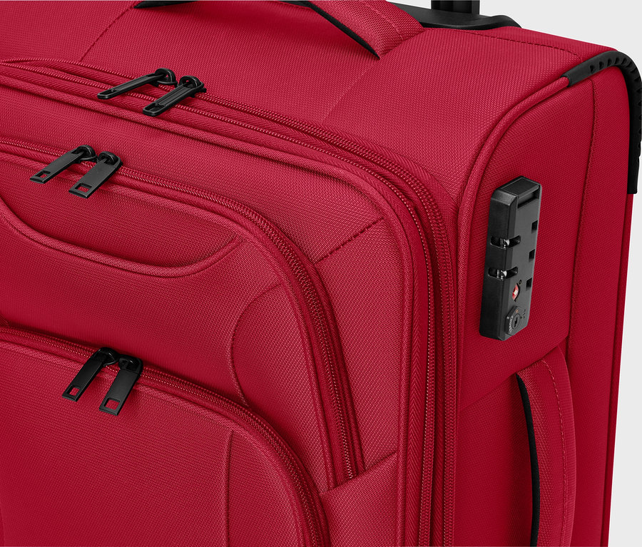 Közelkép egy piros szövetbőröndről fekete cipzárral és számzáras lakattal.