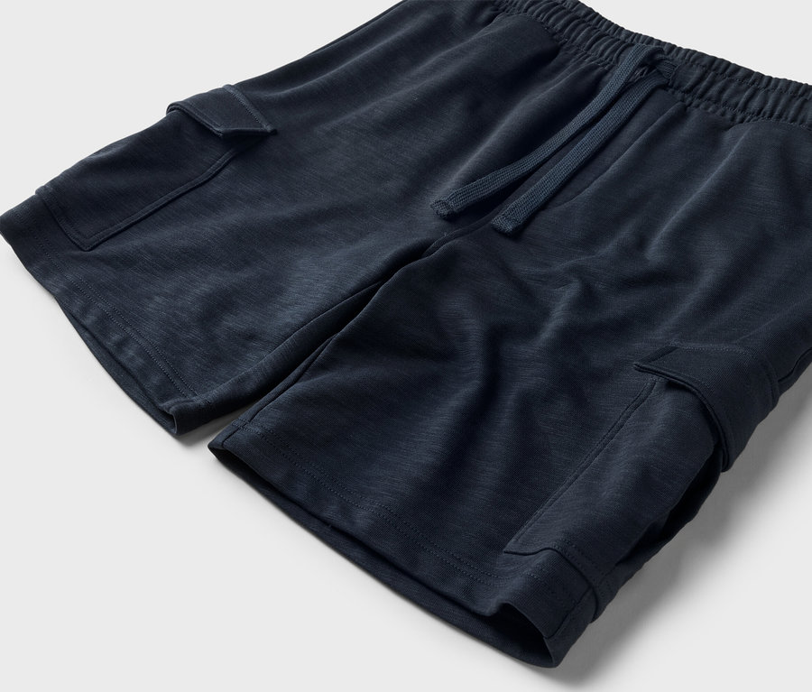 Közeli kép egy sötétkék színű rövidnadrágról húzózsinórral és oldalzsebekkel.