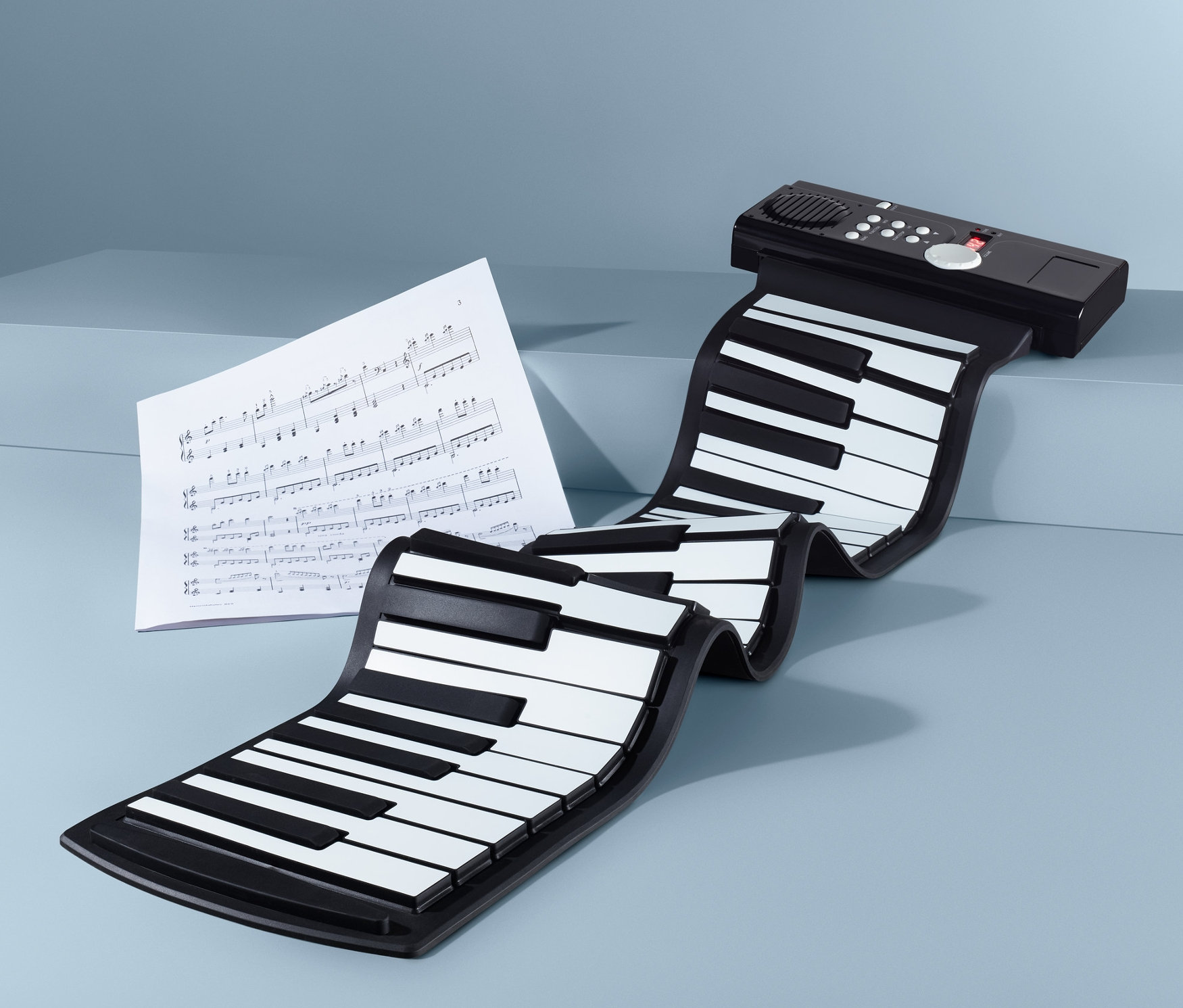 Egy flexibilis szintetizátor kék háttérrel, kottával.