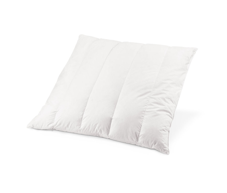 Közeli kép egy steppelt, fehér cirbolyafenyő párnáról.