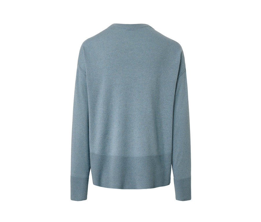 Egy kék, kasmír anyagú, finomkötésű női pulóver részlete.