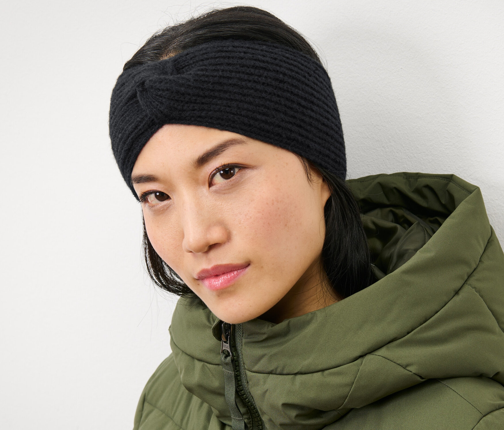 Nő visel egy fekete kötött fejpántot.