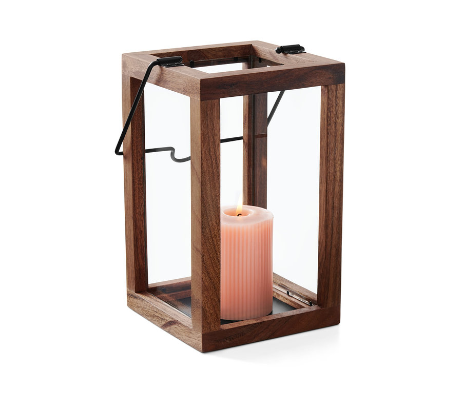 Rózsaszín gyertya ég egy fa lámpásban, üvegfalakkal.