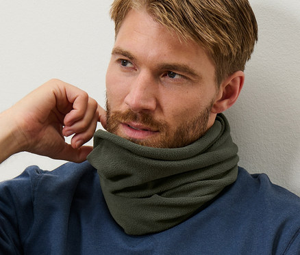 Barna hajú, szakállas férfi kék pulóvert és khaki termo polár csősálat visel.