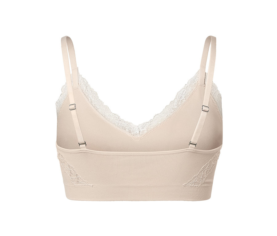 Egy krémszínű, varrás nélküli, csipkés bustier részletfotója.