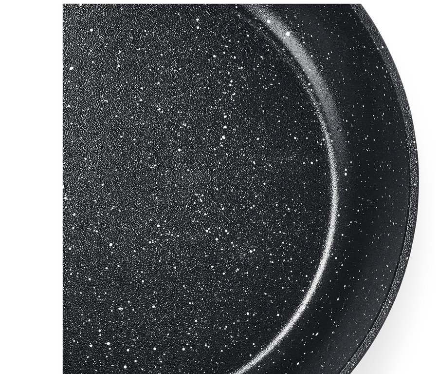 Közeli felvétel egy fekete, kőhatású serpenyő belső felületéről, fehér pöttyökkel.