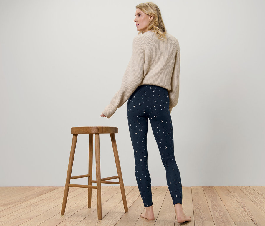 Nő áll háttal a kamerának, csillag és hold mintás női leggings van rajta.