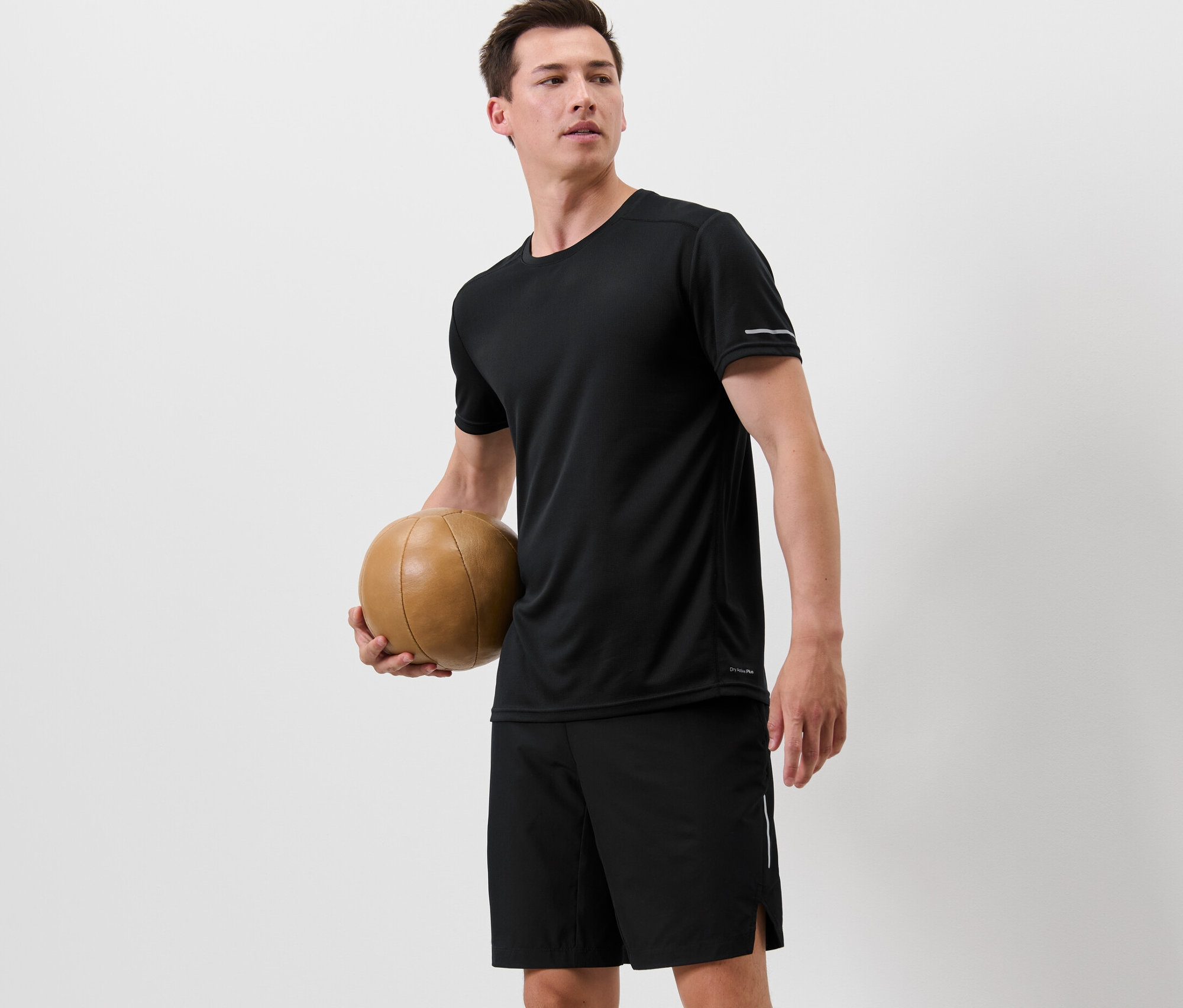 Férfi kosárlabdát tart és fekete funkcionális felsőt visel.