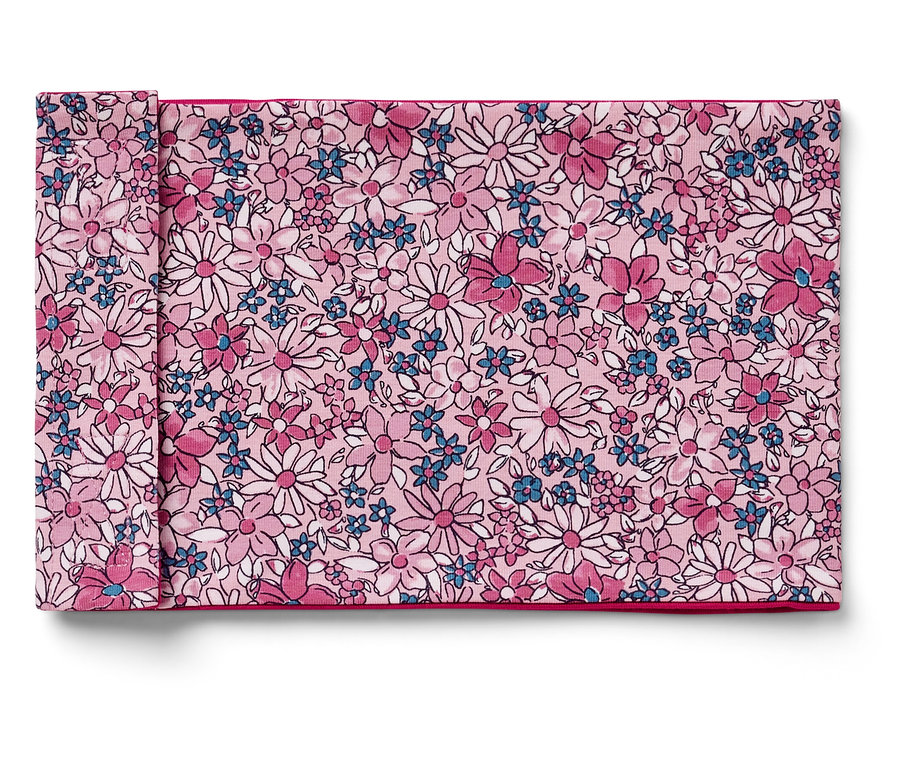 Egy rózsaszín, fehér és kék virágmintás, összehajtott szövet szalvéta.