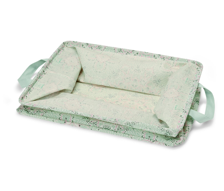 Egy világoszöld, virágmintás, összecsukható tárolódoboz világoszöld fogantyúkkal.