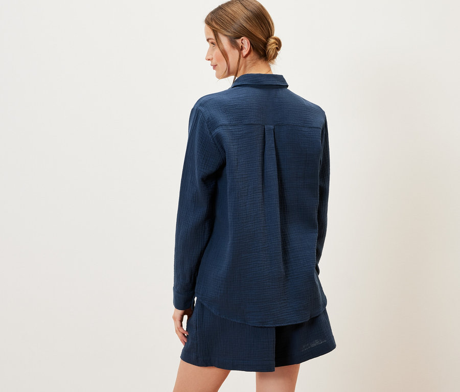 A hátulról látható nő tengerészkék muszlinblúzt visel.