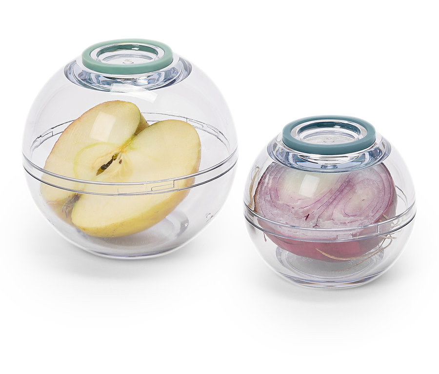 Egy fél alma egy nagy, átlátszó tartályban és egy vöröshagyma egy kisebb, átlátszó tartályban.