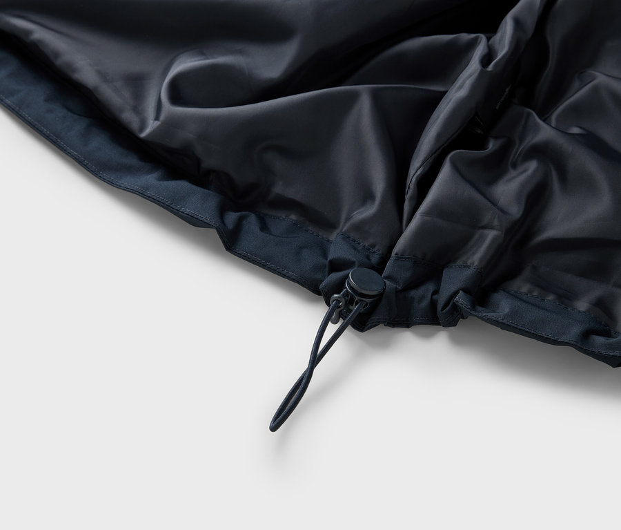 Egy sötétkék kabát zsinóros belső részének részletes nézete.