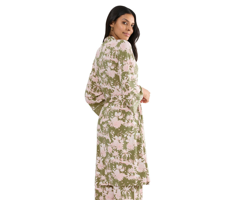 Nő visel egy zöld, rózsaszín virágmintás köntöst övvel.